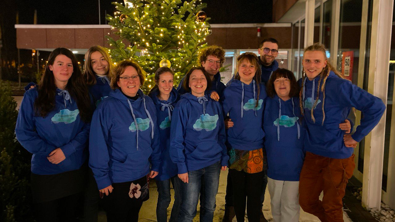 Farmteam und Vorstand vor einem Weihnachtsbaum