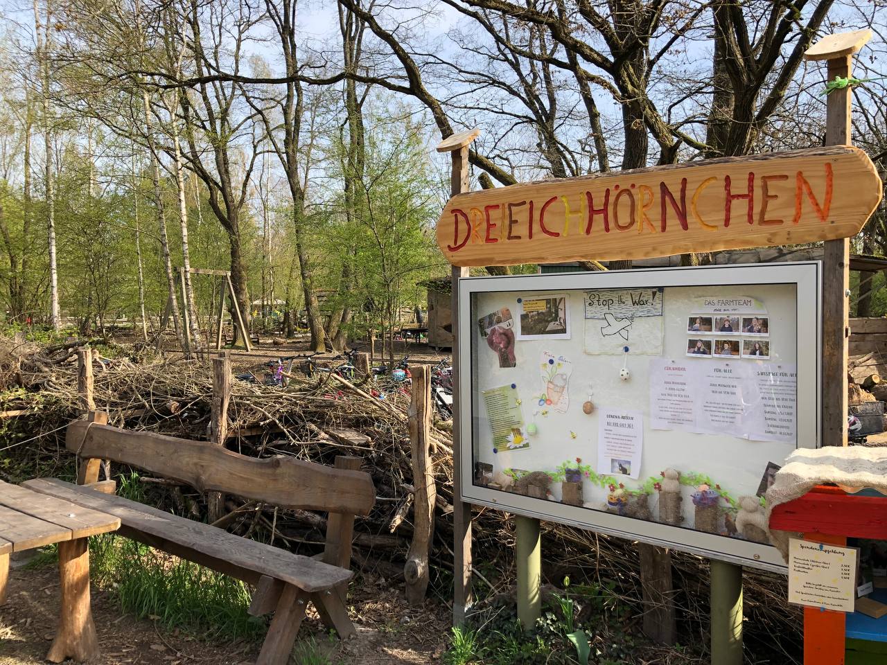 Benjeshecke und Infotafel am Eingangsbereich der Farm.